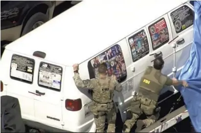  ?? ASSOCIATED PRESS ?? This frame grab from video provided by WPLG-TV shows FBI agents covering a van after the tarp fell off as it was transporte­d from Plantation, Fla., as federal agents and police officers examined it in connection with the mailing of package bombs.