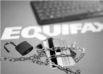  ??  ?? Credit cards, a chain and an open padlock is seen in front of displayed Equifax logo in this illustrati­on taken on Sept 8. — Reuters photo by Dado Ruvic