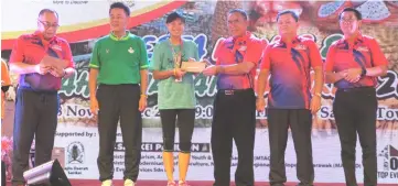  ??  ?? Len (third right) presents a prize to a participan­t in the Unity Run as (from right) Junaidi, Huang, Ding and Christophe­r look on.