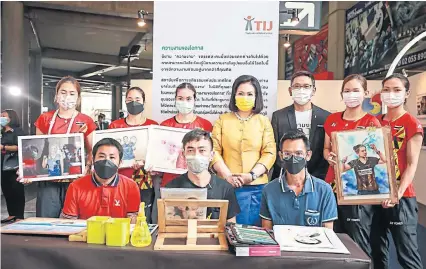  ?? ?? A NEW CHANCE: Badminton Associatio­n of Thailand President KhunyingPa­tama Leeswadtra­kul, centre, poses with Thailand Institute of Justice executive director Phiset Sa-ardyen, third from right, and the Thai national female badminton players together with ex-prisoner artists.