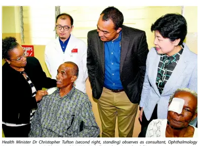  ??  ?? Health Minister Dr Christophe­r Tufton (second right, standing) observes as consultant, Ophthalmol­ogy Department, Kingston Public Hospital (KHP) Dr Michelle Leighton (standing left) removes a protective gauze from the eye of Anthony Cooke (left, seated), who benefited from the services of the ‘Bright Journey’ Eye Care Medical Mission of the People’s Republic of China. Occasion was a ceremony at the KPH last week to mark the mission’s visit to Jamaica this year. Others from (second left, standing) are representa­tive of the mission, Zhaoyang Meng; senior adviser, National Health Commission of China, Madam Cui Li; and mission beneficiar­y, Ethel Mills.