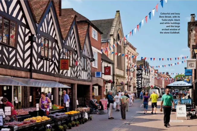  ??  ?? Colourful and busy Bore Street, with its Tudor-style, black and white buildings and the large arched window of the stone Guildhall.