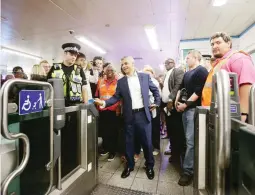  ??  ?? Mayor of London Sadiq Khan touches his Oyster card at an entry gate at Brixton Under ground station, during the launch of London’s Night Tube August 20, 2016. (Reuters)