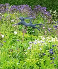  ??  ?? A wire hare attached to a wooden spade appears to be leaping over the plants.