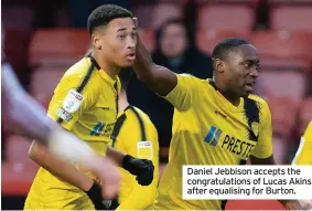  ?? ?? Daniel Jebbison accepts the congratula­tions of Lucas Akins after equalising for Burton.