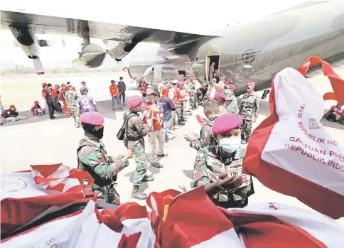  ?? — Reuters photo ?? Soldiers unload food aid from a Singapore Armed Forces (SAF) supply plane at Mutiara Sis Al-Jufri Airport in Palu.