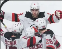  ?? GRAHAM HUGHES - THE ASSOCIATED PRESS ?? New Jersey Devils’ Kyle Palmieri (21) celebrates with teammates Taylor Hall (9), Nico Hischier (13) and Damon Severson (28) after scoring against the Montreal Canadiens during overtime in an NHL hockey game in Montreal, Saturday, Nov. 16, 2019.