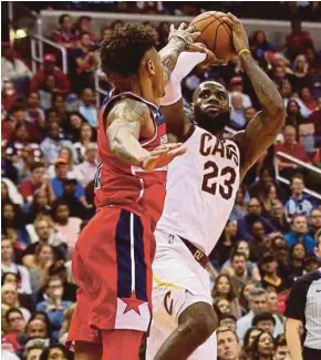  ?? REUTERS PIC ?? Cleveland Cavaliers’ LeBron James shoots over Washington Wizards’ Kelly Oubre Jr. on Friday.