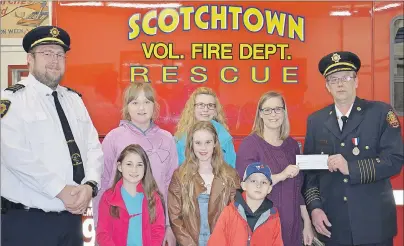  ?? SUBMITTED PHOTO/ASHLEY OSBORNE ?? Laurie Gardiner, back right, of Gardiner Mines, accepts a cheque for $1,000 from Chief Raymond Eksal of the Scotchtown Volunteer Fire Department. The money will be used to purchase an automated external defibrilla­tor for Greenfield School in River...