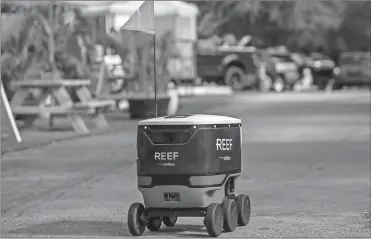  ?? Jose A. Iglesias/el Nuevo Herald/tns ?? A delivery robot runs along the road in Section 9, located in the Brickell area of Miami, among restaurant­s operated by REEF.