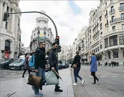  ?? DANI DUCH ?? Dos ciutadans van de compres per la Gran Vía, una de les principals artèries comercials de Madrid