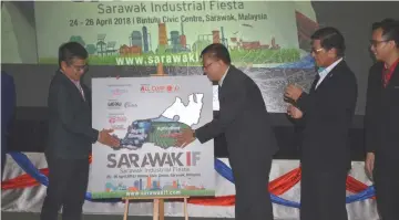  ??  ?? Dr Annuar (left) and Bujang (third right) place the Sarawak growth nodes on the map of Sarawak.