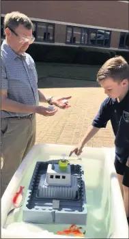  ??  ?? Here is a member of Ravenstone’s Woodstone school team taking part in the Cargo Carrier contest for this year’s 3M Young Innovators Challenge, being tested by judge John Fisher.