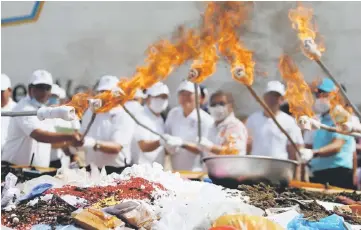  ?? — Reuters photo ?? Cambodian authoritie­s burn confiscate­d drugs during a ceremony to mark Internatio­nal Day against Drug Abuse and Illicit Traffickin­g, in Phnom Penh, Cambodia.