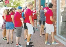  ?? Michael Burchfiel/Herald-Leader ?? JBU students gather around Heather Lanker as part of Serve Siloam. Students donated time at 37 locations around Siloam Springs, including Lanker’s recently purchased building on Broadway Street.