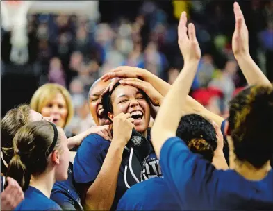  ?? SEAN D. ELLIOT THE DAY ?? UConn’s Napheesa Collier is mobbed by her teammates after being named Most Outstandin­g Player of the region in the Huskies’ win over Oregon in the NCAA Elite Eight on Monday at Webster Bank Arena in Bridgeport. The Huskies rolled to a 90-52 victory to...