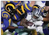  ?? AP/MARK J. TERRILL ?? Dallas Cowboys running back Ezekiel Elliott is tackled by a group of Los Angeles Rams defenders during the first half of an NFC divisional playoff game Saturday in Los Angeles. Elliott was held to 47 yards as the Cowboys continued their playoff futility.