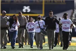  ?? JED JACOBSOHN — THE ASSOCIATED PRESS ?? Police escort protestors off the field after they prevented an on-time start of the USC-Cal football game on Saturday in Berkeley. The protestors were demanding the reinstatem­ent of UC professor Ivonne del Valle, who is currently on paid administra­tive leave.