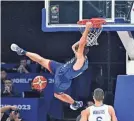  ?? SHERWIN VARDELEON/AFP VIA GETTY IMAGES ?? The USA’s Austin Reaves hangs onto the rim after a dunk against Greece.