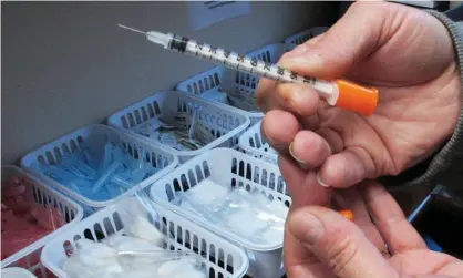  ?? Photograph: Rick Callahan/AP ?? A nurse holds a needle used in a needle exchange program.