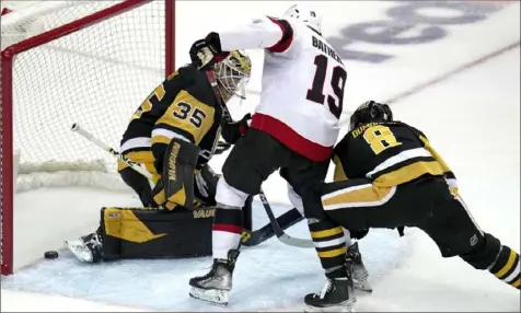  ?? Gene J. Puskar/Associated Press ?? The Senators’ Drake Batherson gets a shot past Penguins goaltender Tristan Jarry with the Penguins’ Brian Dumoulin defending for a goal during the third period Monday at PPG Paints Arena.