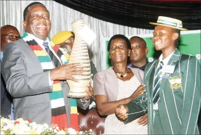  ?? — (Picture by Kudakwashe Hunda) ?? President Mnangagwa displays a token of appreciati­on he received from a Girls High School pupil (right), while Secretary for Primary and Secondary Education Dr Sylvia Utete-Masango (middle) looks on at the launch of exercise books and e-learning kits in Harare yesterday.