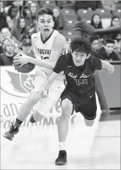  ?? Herald photo by Tijana Martin ?? Nick Gibb of the Catholic Central Cougars makes his way past Anfernee Houmphanh of the Medicine Hat Mohawks during the 4A Boys B-Side semifinal at the 1st Choice Savings Centre at the University of Lethbridge on Friday night.