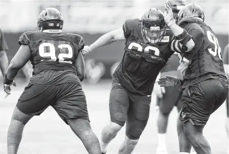  ?? Brett Coomer / Staff photograph­er ?? Defensive end J.J. Watt, center, displays some of his old form as he bulls between Texans teammates Brandon Dunn, left, and D.J. Reader during a drill at training camp this week. Watt is coming off consecutiv­e injury-marred seasons.