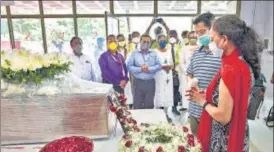  ?? PTI ?? Captain Deepak Sathe’s wife, Sushma, and son, Dhananjay, pay tributes to the Air India Express pilot at n the Mumbai airport on Sunday.