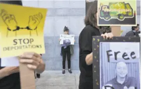  ?? Josh Edelson / Special to The Chronicle ?? Protesters hold up signs as they rally in support of two Bay Area men who may be deported because of past conviction­s after decades living in the U.S.