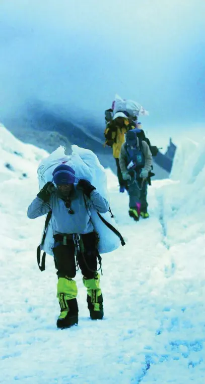  ?? AP ?? Un grupo de sherpas asciende por el valle del Khumbu, en Nepal, en la ruta por la cara sur del Everest
