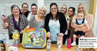  ??  ?? Roll upvoluntee­rs behind the tombola stall at the Reflex Summer Fun Day