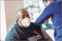  ?? Joseph Prezioso / Getty Images ?? Frank Tate, a staff member and former client of The Open Hearth men’s shelter, receives the Pfizer-BioNTech COVID-19 vaccine from a Mobile Vaccinatio­n Clinic run by Hartford HealthCare in Hartford last week.