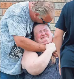  ?? MICHAEL CIAGLO/AP ?? A man hugs a woman outside Alamo Gym as parents waited to reunite with their children following the Santa Fe High School shooting.