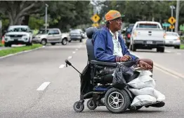  ?? Dirk Shadd / Associated Press ?? John Jelkl, 71, has his wheelchair loaded down as he leaves a sandbaggin­g site in St. Petersburg, Fla., before Elsa hits. “I stay in a place that is low,” Jelkl said.