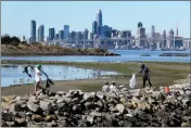  ?? RAY CHAVEZ — BAY AREA NEWS GROUP ?? Oliver Arnold, 12, left, of Oakland, and other volunteers take part in the annual Coastal Cleanup Day at Middle Harbor Shoreline Park Beach in Oakland.