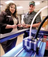  ?? Democrat-Gazette file photo/BEN GOFF ?? Benton County Agent Jessica Street looks over a 3-D printer May 8 with James Simpson, president of the county’s 4-H Club Foundation, during a centennial celebratio­n of the Smith-Lever Act, which created the U.S. Agricultur­e Extension Service in 1914.