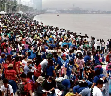  ?? MARIANNE BERMUDEZ ?? THOUSANDS of volunteers as far as the eye can see crowd the shore of Manila Bay to pick up trash on Internatio­nal Coastal Cleanup Day yesterday.