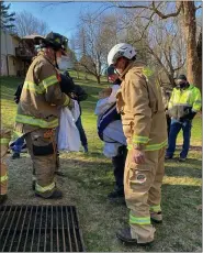  ?? SUBMITTED PHOTO ?? Firefighte­rs wrap Fox the Corgi in a blanket after being rescued from a storm water grate in Westtown Township Dec. 26.