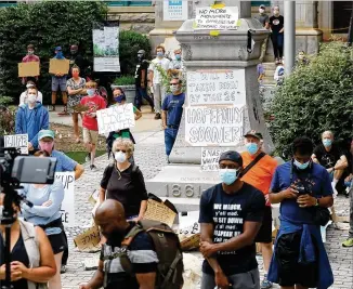  ?? PHOTOS BY CURTIS COMPTON / CCOMPTON@AJC.COM ?? Protesters at a rally Wednesday call for removal of a Confederat­e monument to the “Lost Cause” that has been on Decatur Square since 1908.