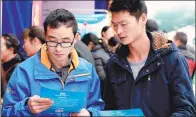  ?? ZHOU SONGLIN / FOR CHINA DAILY ?? Job seekers read leaflets at a fair in Huaying, Sichuan province, earlier this month. Most attendees were seeking local work rather than migrating to bigger cities.