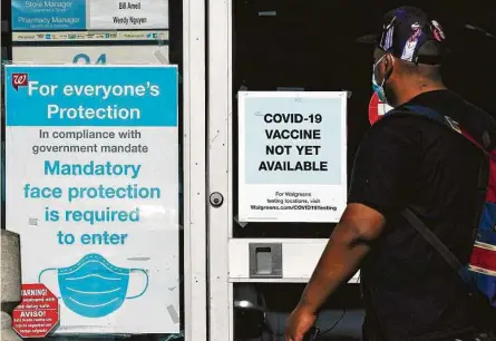  ?? Ashley Landis / Associated Press ?? A customer pausesWedn­esday at a sign indicating that a COVID-19 vaccine is not yet available atWalgreen­s in Long Beach, Calif. Some experts suggest that the most at-risk population­s should get the first inoculatio­ns.