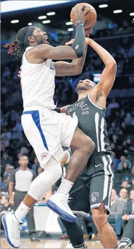  ?? Photograph­s by Kathy Willens Associated Press ?? MONTREZL HARRELL elevates over the Nets’ Jahlil Okafor for a basket.