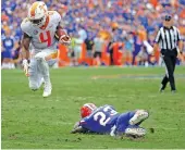  ?? THE ASSOCIATED PRESS ?? Tennessee running back John Kelly leaps over Florida defensive back Chauncey Gardner Jr. for extra yardage on a run during Florida’s 26-20 win on Saturday.