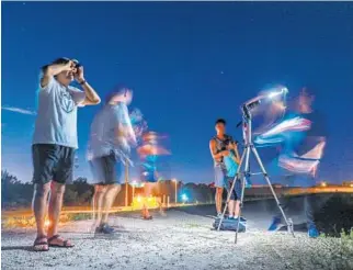  ?? JENNIFER LETT/SOUTH FLORIDA SUN SENTINEL ?? Ricardo Camacho looks for the NEOWISE comet at Markham Park in Weston after biking along the levee at the west end of the park on Monday.