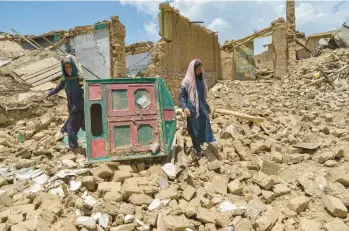  ?? AHMAD SAHEL ARMAN/GETTY-AFP ?? Earthquake fallout: Afghan men comb the ruins of a damaged house for their belongings Thursday in Paktika province, the epicenter of Wednesday’s magnitude 6.0 temblor. State media reported that at least 1,000 people died, but U.N estimates gave a lower death toll, saying around 770 people had been killed in Paktika and Khost provinces.