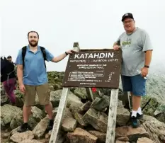  ?? ?? Garrett Burd, left, and Mark Burd atop Mount Katahdin, Maine's highest point and the northern end of the Appalachia­n Trail. It is the East Coast's most challengin­g climb.