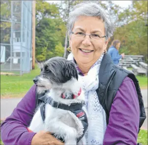  ?? KATIE SMITH/THE GUARDIAN ?? Joan Atkinson of Guernsey Cove is shown at the Pawd in the Park event on Oct. 15 at Victoria Park in Charlottet­own with her adopted dog, Pippy.