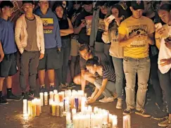  ??  ?? ‘SO FULL OF LOVE’: Mourners attend a candleligh­t vigil for the tragic Trinidad family Saturday evening in Teaneck’s Votee Park.