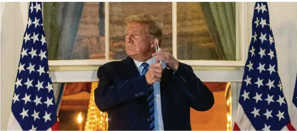  ?? FOTO: PICTURE ALLIANCE ?? Inszenieru­ng vor den Kameras nach der Entlassung aus dem Krankenhau­s: US-Präsident Trump präsentier­t sich auf dem Balkon des Weißen Hauses – und zieht sich sogleich die Maske vom Gesicht. „Habt keine Angst vor Covid. Lasst nicht zu, dass es euer Leben beherrscht“, empfahl er den Amerikaner­n. Viele Angestellt­e indes sehen sich mit Trumps Rückkehr einem hohen Risiko ausgesetzt.